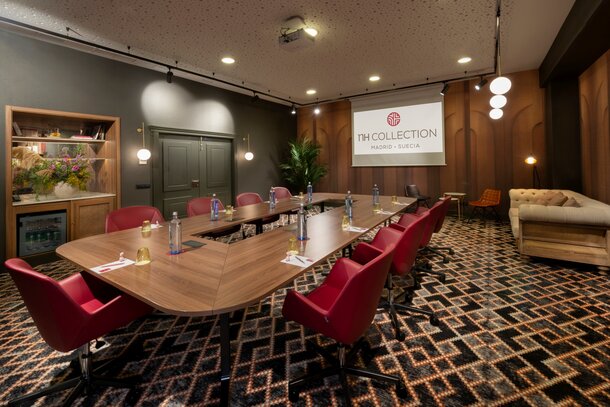 Conferece room with a nice table and red chairs.