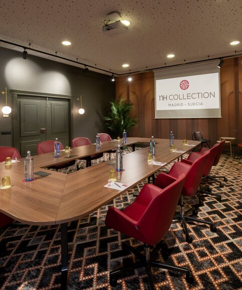 Conferece room with a nice table and red chairs.