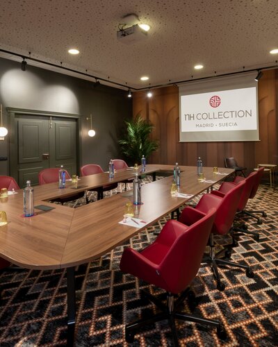 Conferece room with a nice table and red chairs.