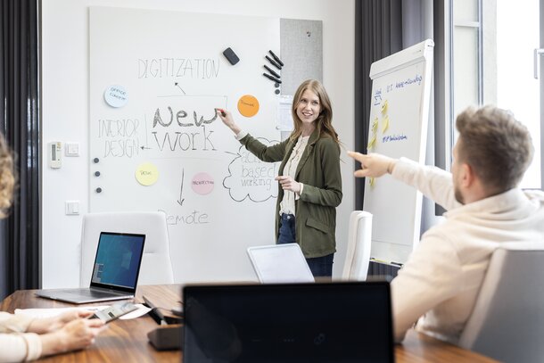 Person erklärt etwas auf einem Whiteboard.