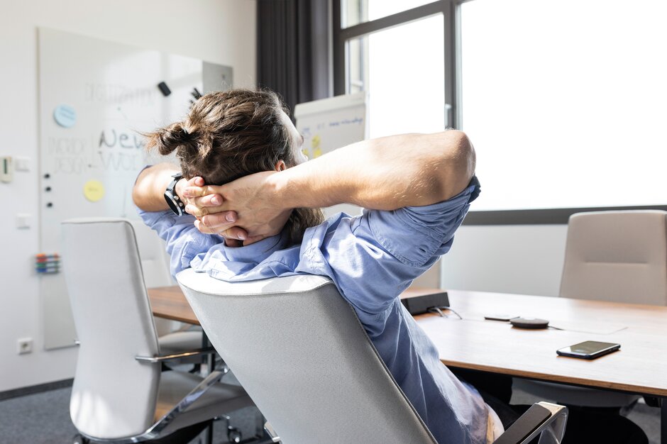 Person leans back in a conference chair.