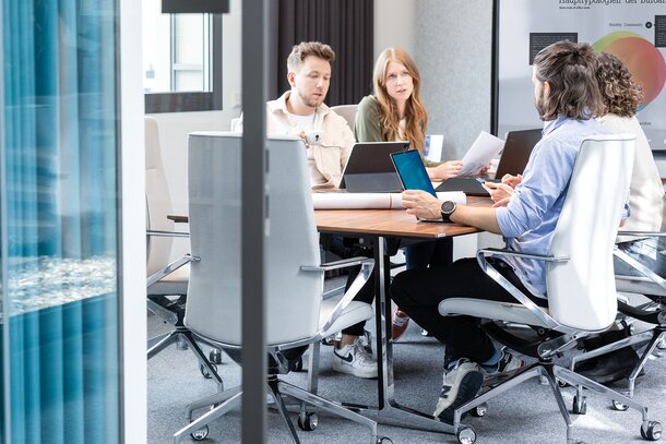 Four people in a conference room.