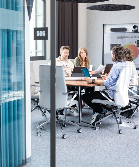 Four people in a conference room.