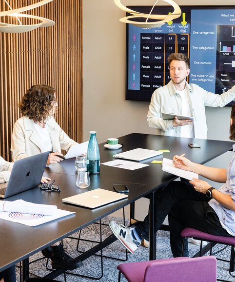 Vier Personen die ein Meeting in einem Working Café haben.