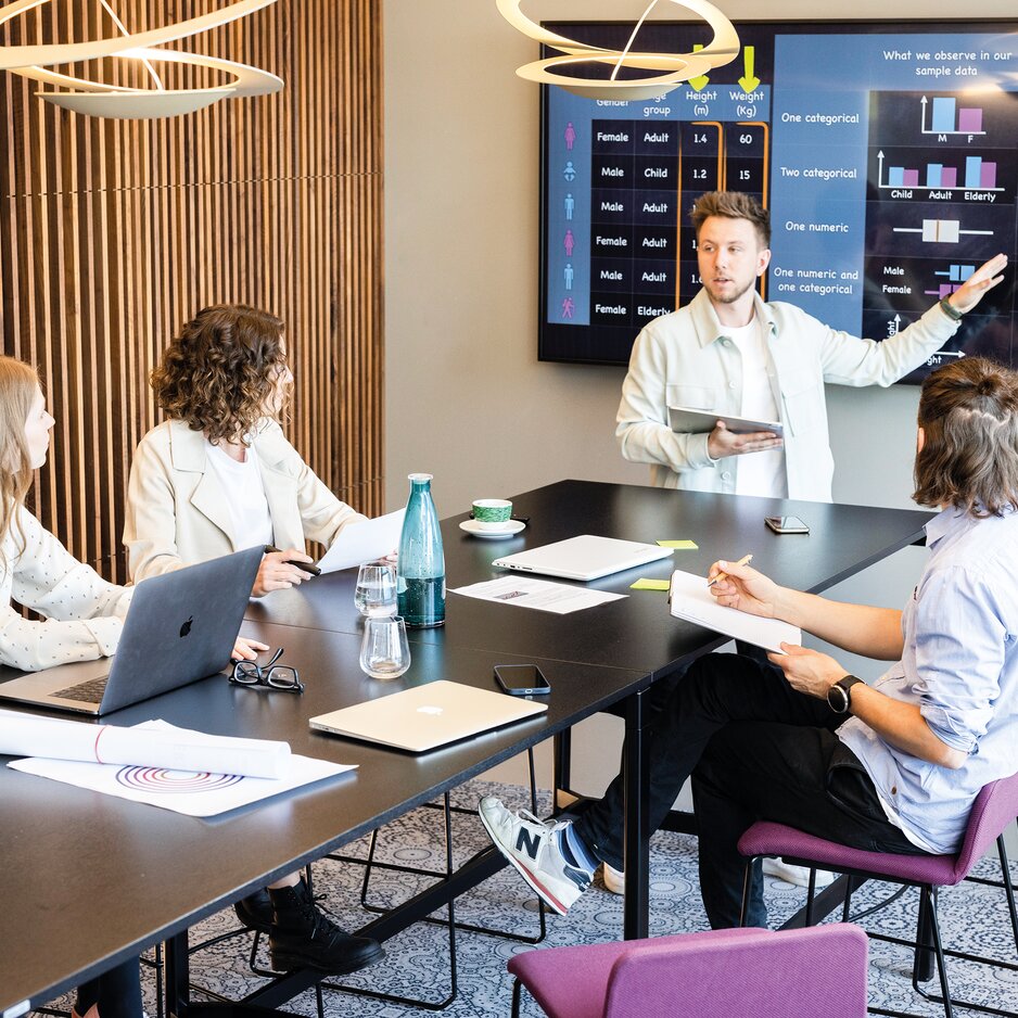 Vier Personen die ein Meeting in einem Working Café haben.