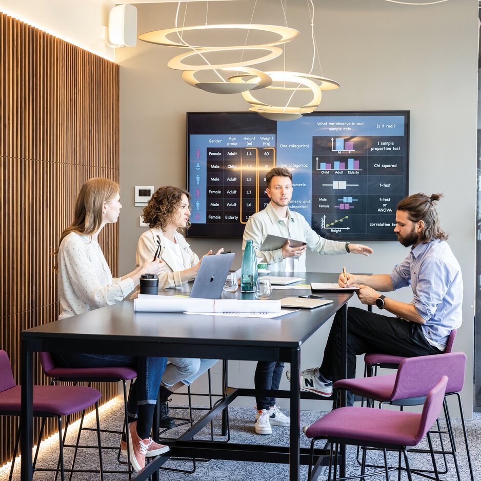 Vier Personen die ein Meeting in einem Working Café haben.