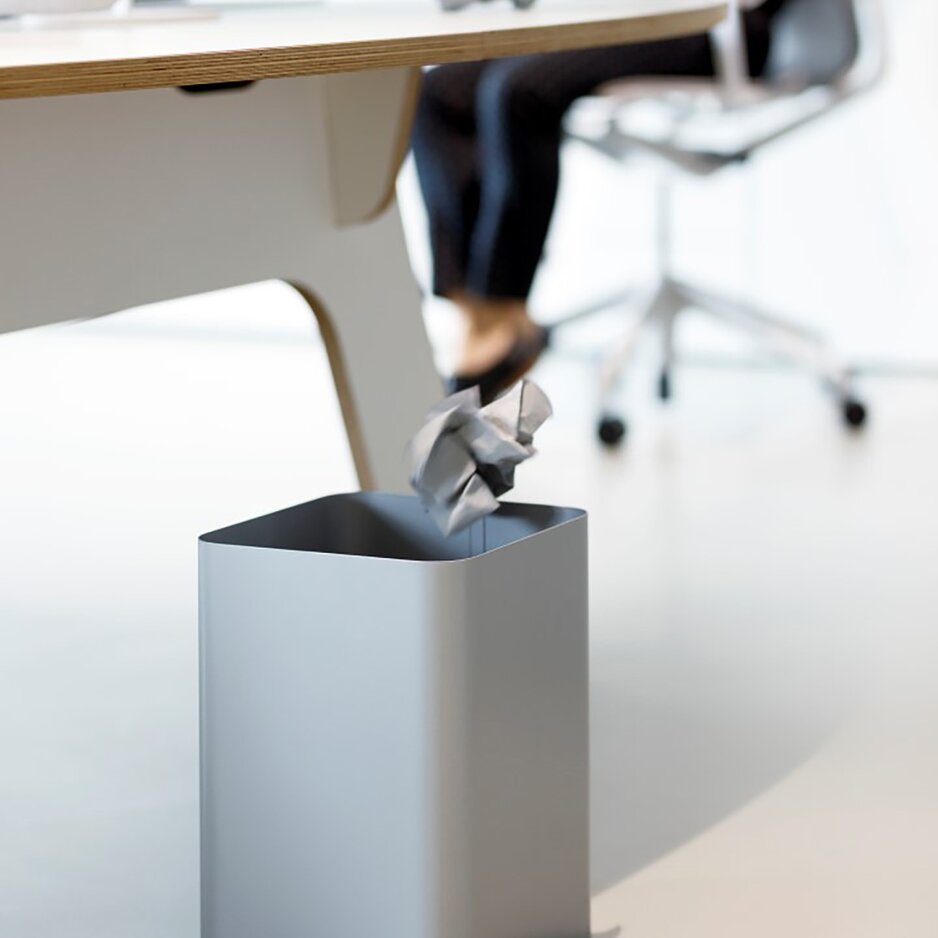 Gray waste paper basket in an office.