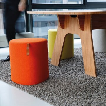 Colourful poufs in front of a table.