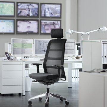 Black swivel chair in front of a desk.