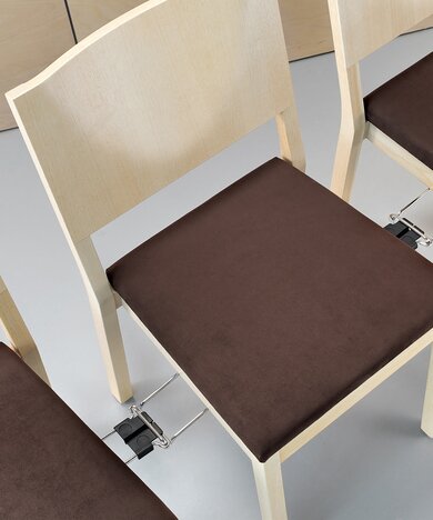systeem voor het in elkaar haken van stoelen zodat deze in een rij kunnen worden opgesteld