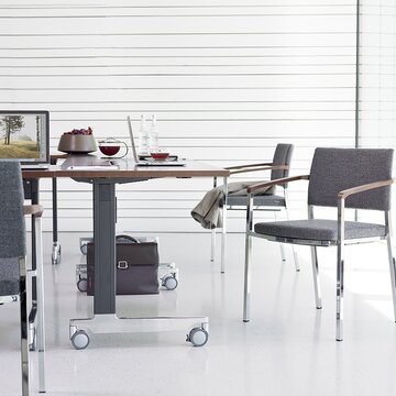 Grauer Stuhl an einem Konferenztisch.