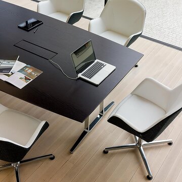 Dark conference table with cable management.