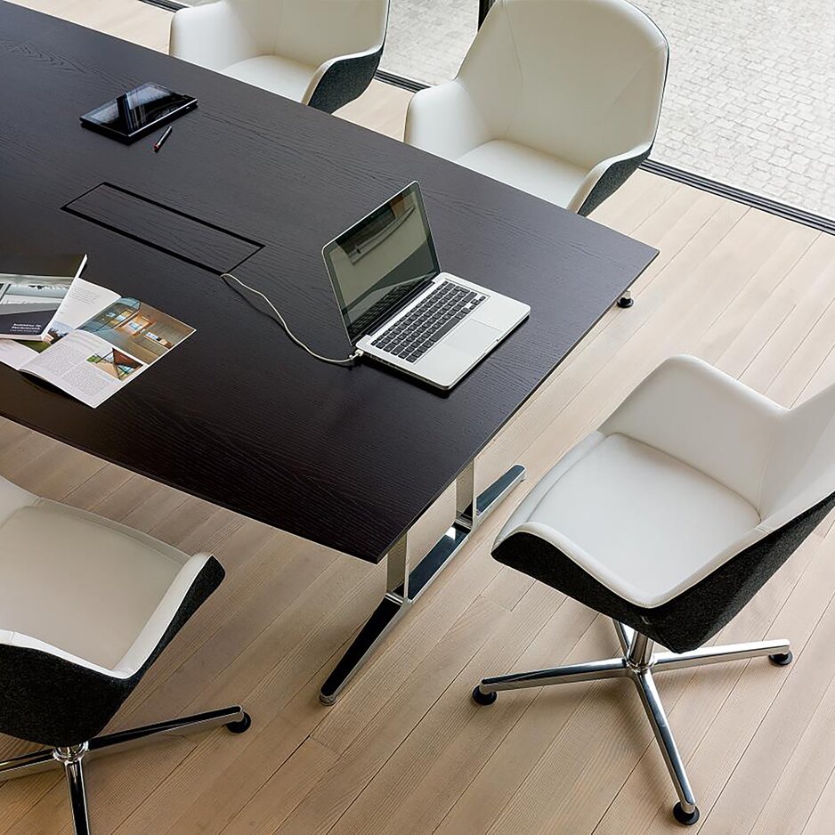 Dark conference table with cable management.
