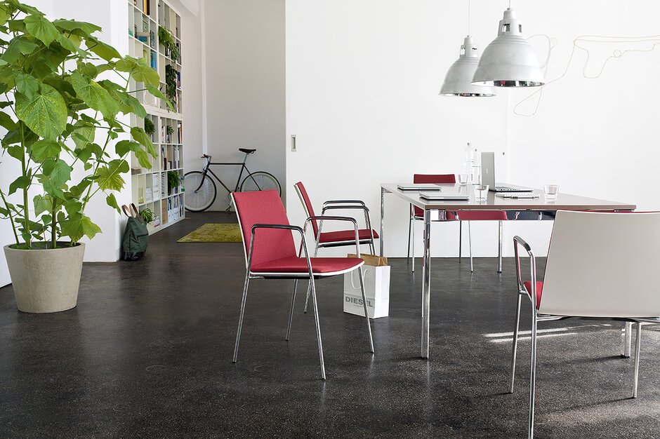 stoelen met rode stoffering aan een rechthoekige tafel