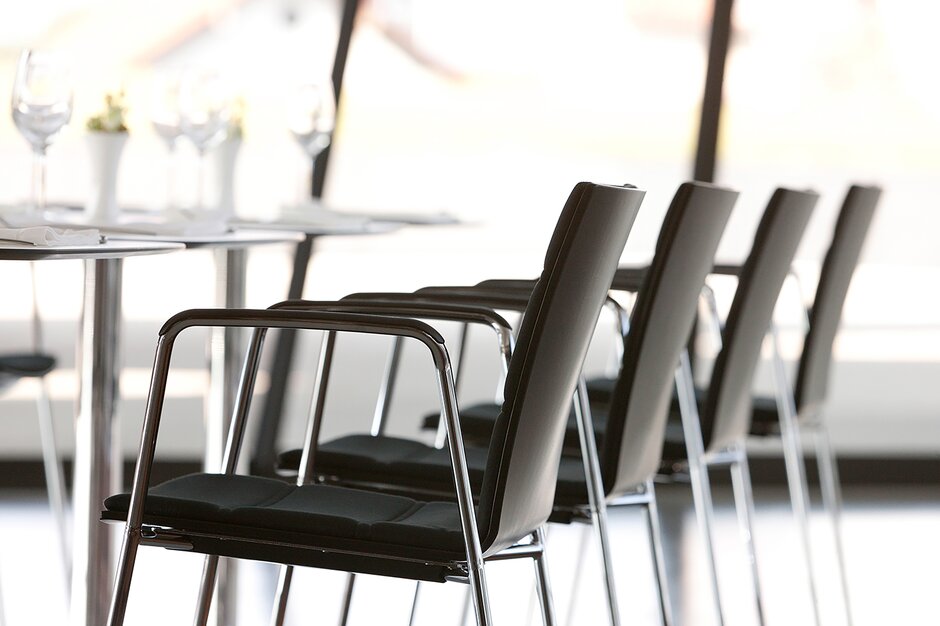 vue détaillée d'un bistro avec chaises noires avec accoudoirs et tables
