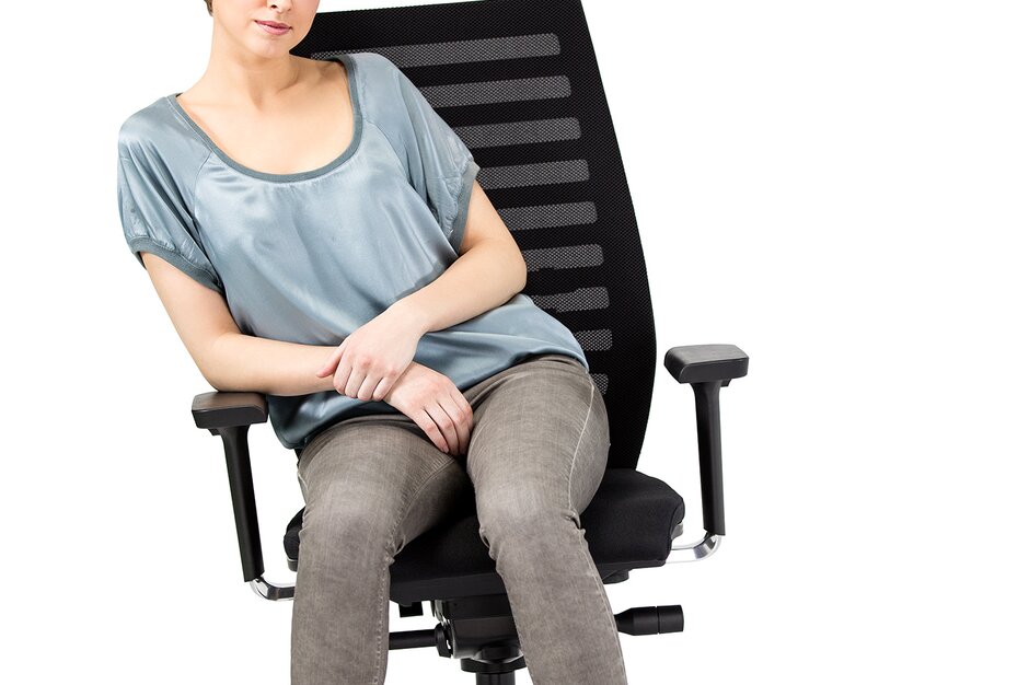 Frau sitzt auf schwarzem Bürostuhl.