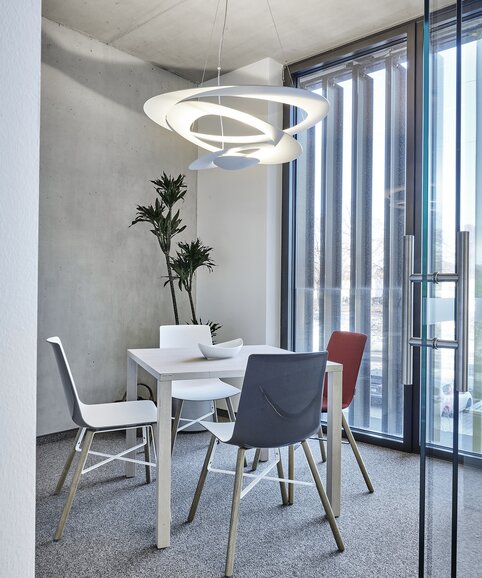 Showroom Graz White table with three chairs.
