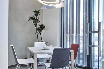 Showroom Graz White table with three chairs.