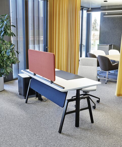 Workplace in front of a yellow curtain.