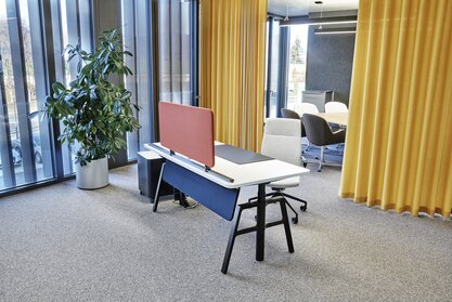 Showroom Graz Workplace in front of a yellow curtain.