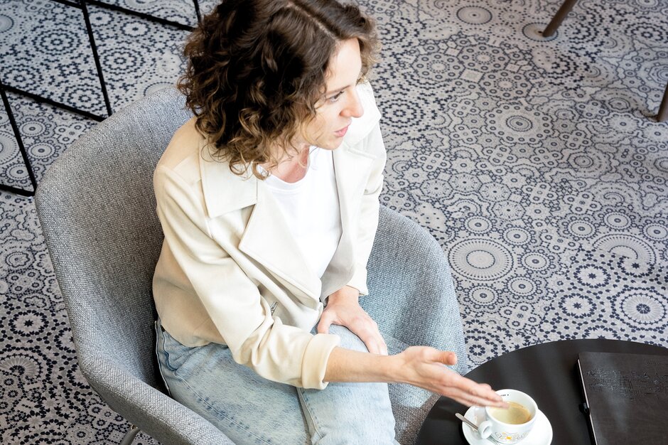 Person is drinking coffee at a bistro table.