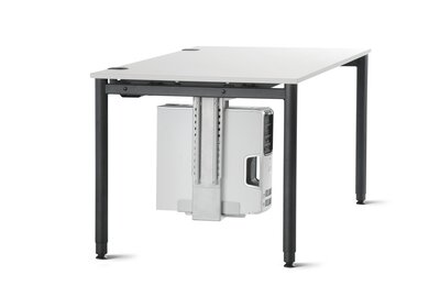 Vue latérale d’un ordinateur de bureau placé dans un support monté sous une table