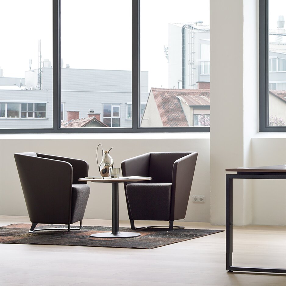 Zwei braune Fauteuil in einem Büro.
