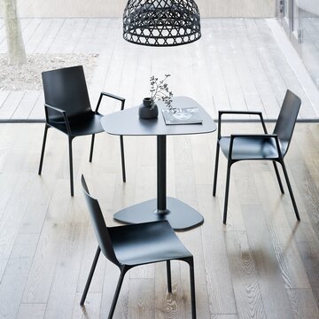 Black chairs with a black bistro table photographed from above.
