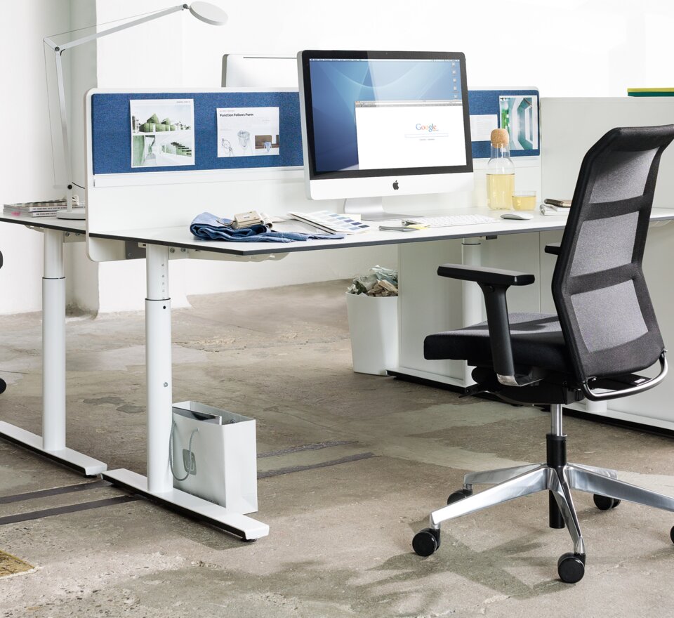 Office with two desks, black swivel chairs and a white cabinet. 