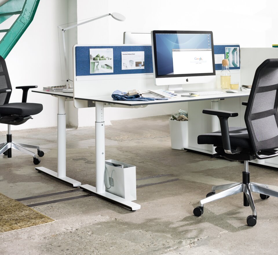 Office with two desks, black swivel chairs and a white cabinet. 