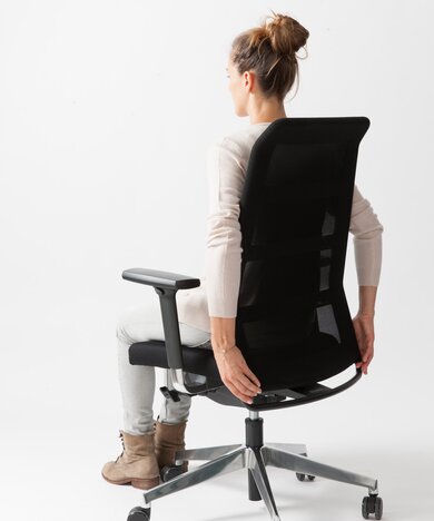 Person is sitting on a black swivel chair.