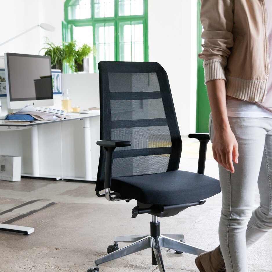 Person is standing in front of a black swivel chair.