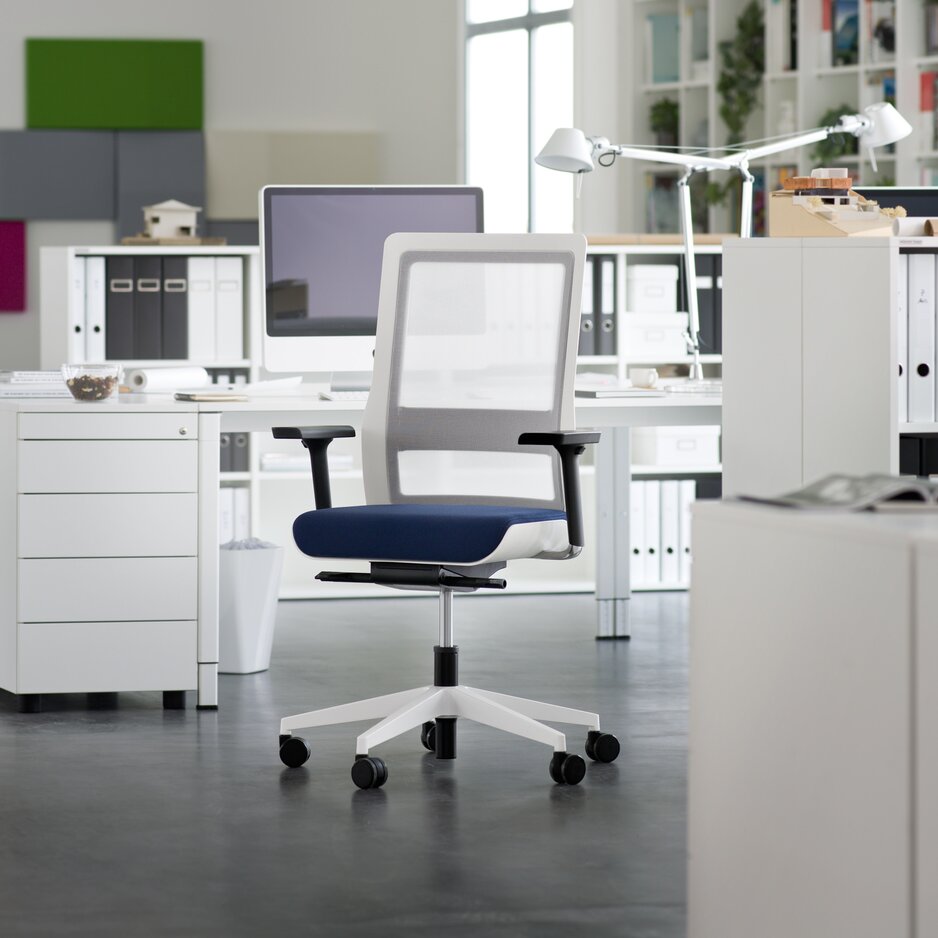 White swivel chair with blue padded seat in an office.
