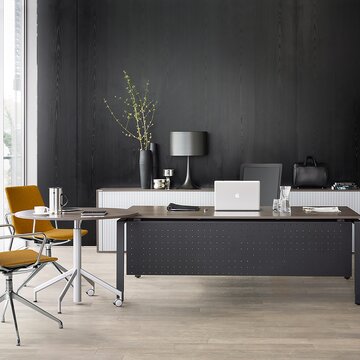 Black office desk and yellow swivel chairs.