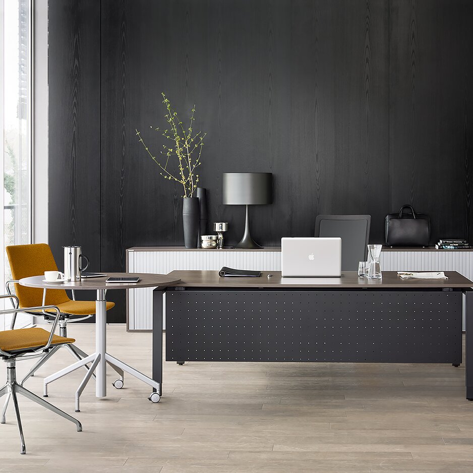 Black office desk and yellow swivel chairs.
