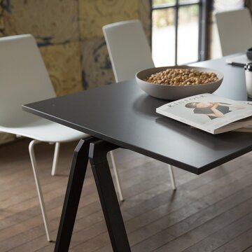 Black stacking table with white chairs.