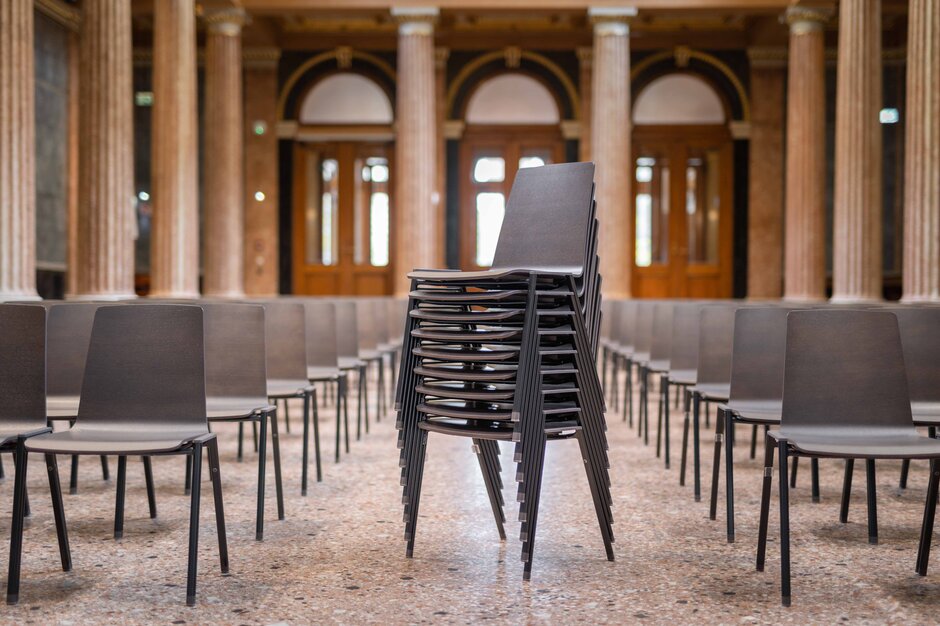 Academie der beeldende kunsten | © Martin Zorn Photography Indrukwekkende hal met rijen stoelen en een stapel stoelen | © Martin Zorn Photography