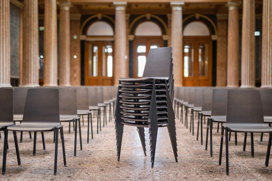 Salle impressionnante avec rangées de chaises et des chaises empilées | © Martin Zorn Photography