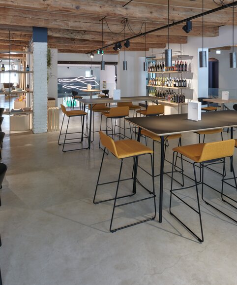Café avec tables bistro, sièges, tabourets de bar et tables hautes