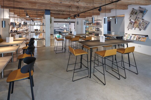 Café avec tables bistro, sièges, tabourets de bar et tables hautes