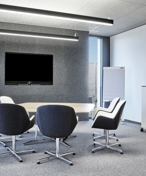 Meeting room with conference furniture and screen.