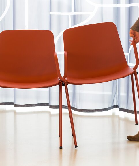 Zwei  rote Stühle die verkettet sind. | © Etienne Oldeman Photography