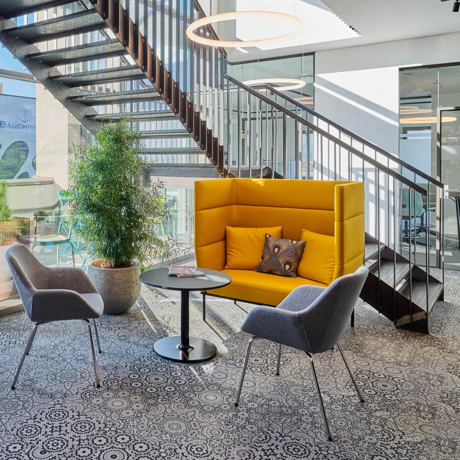 Yellow lounge seating with two gray conference chairs. | © raumpixel.at