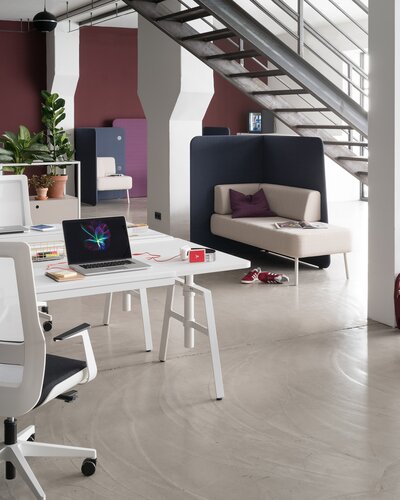 Teambüro mit weißen Möbeln und einer roten Wand.