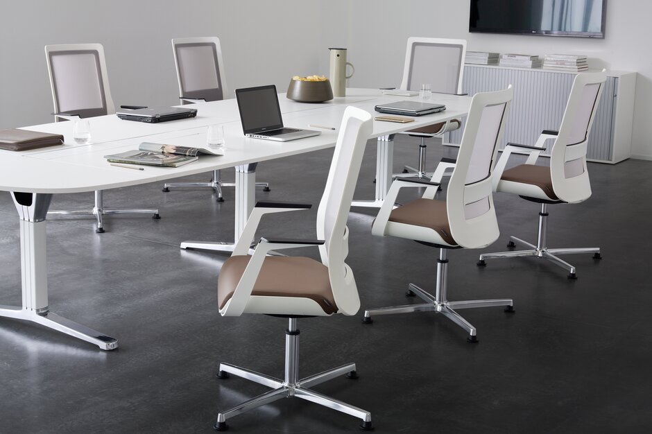 White conference chairs at a white conference table.