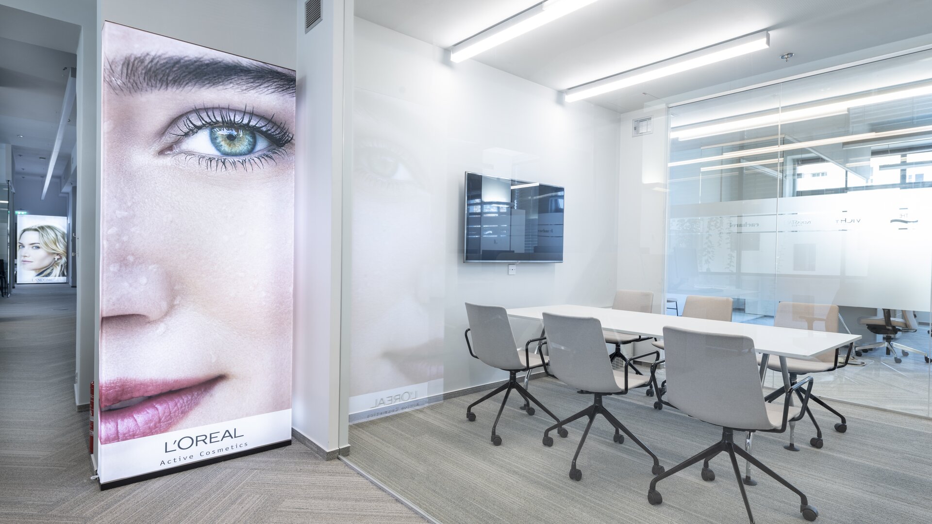 L'Oréal | © Saša Dobrovodský Salle de réunion avec table, chaises et une grande affiche | © Saša Dobrovodský