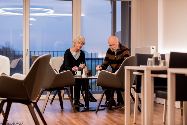 Twee oudere mensen zitten aan een bistrotafel. | © Passauer Wolf