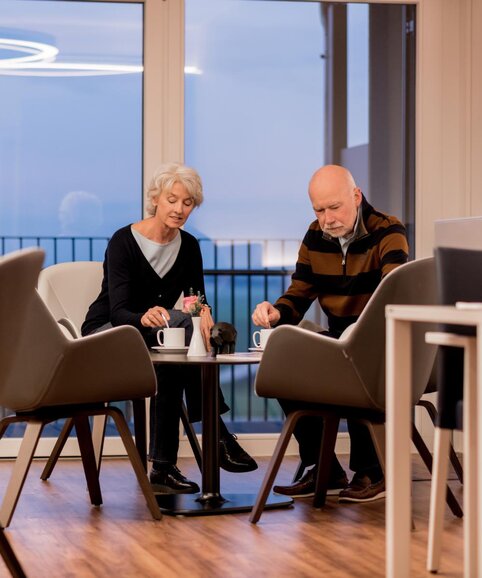 Twee oudere mensen zitten aan een bistrotafel. | © Passauer Wolf