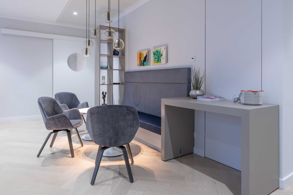 Lounge area with gray chairs and hanging lamps | © Martin Zorn Photography