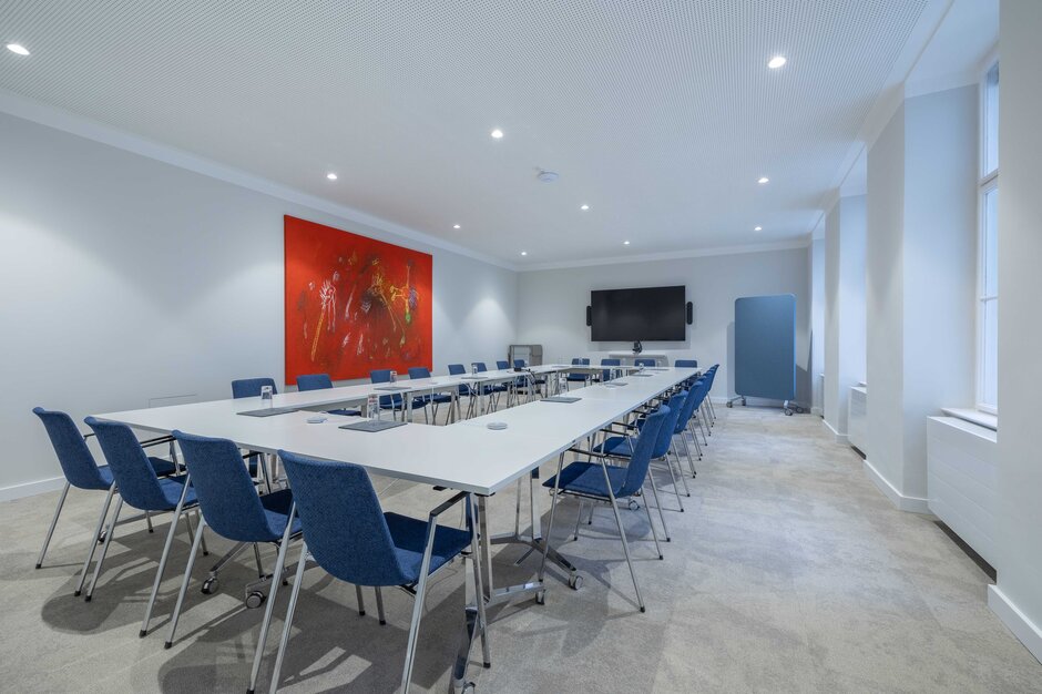 Konferenzraum mit blauen Stühlen und einem roten Bild an der Wand. | © Martin Zorn Photography